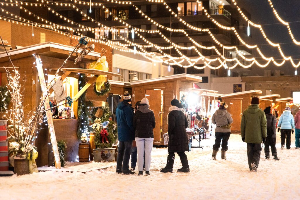 Des personnes profitent des kiosques du marché de Noël.